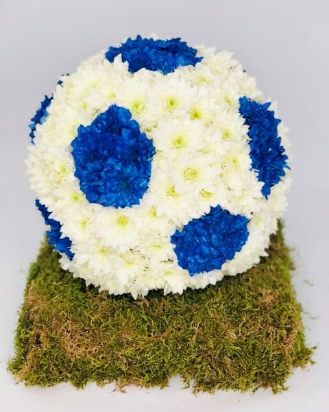 <h2>Football Tribute | Funeral Flowers</h2>
<ul>
<li>Approximate Size 30cm x 25cm</li>
<li>Hand created blue and white football - other colours available</li>
<li>To give you the best we may occasionally need to make substitutes</li>
<li>Funeral Flowers will be delivered at least 2 hours before the funeral</li>
<li>For delivery area coverage see below</li>
</ul>
<br>
<h2>Liverpool Flower Delivery</h2>
<p>We have a wide selection of Bespoke Funeral Tributes offered for Liverpool Flower Delivery. Bespoke Funeral Tributes can be provided for you in Liverpool, Merseyside and we can organize Funeral flower deliveries for you nationwide. Funeral Flowers can be delivered to the Funeral directors or a house address. They can not be delivered to the crematorium or the church.</p>
<br>
<h2>Flower Delivery Coverage</h2>
<p>Our shop delivers funeral flowers to the following Liverpool postcodes L1 L2 L3 L4 L5 L6 L7 L8 L11 L12 L13 L14 L15 L16 L17 L18 L19 L24 L25 L26 L27 L36 L70 If your order is for an area outside of these we can organise delivery for you through our network of florists. We will ask them to make as close as possible to the image but because of the difference in stock and sundry items it may not be exact.</p>
<br>
<h2>Liverpool Funeral Flowers | Bespoke Tributes</h2>
<p>A mass of white double spray chrysanthemums are used in this football-themed three-dimensional tribute, with some sprayed blue to create a distinctive pattern. The football is then displayed on a moss-covered base. This bespoke funeral tribute has been loving handcrafted by our expert florists and is an ideal funeral tribute for a football fan or football player.</p>
<br>
<p>Bespoke Funeral Tributes are a way to create a tribute that is truly unique and specially designed for a loved one.</p>
<br>
<p>These are sometimes selected by family members as the main tribute or more often a group of friends or workplace colleagues as a symbol of things they associate with the deceased.</p>
<br>
<p>The flowers are arranged in floral foam, which means the flowers have a water source so they look their very best for the day.</p>
<br>
<p>Containing 30 white double spray chrysanthemums and a moss-covered base.</p>
<br>
<h2>Best Florist in Liverpool</h2>
<p>Trust Award-winning Liverpool Florist, Booker Flowers and Gifts, to deliver funeral flowers fitting for the occasion delivered in Liverpool, Merseyside and beyond. Our funeral flowers are handcrafted by our team of professional fully qualified who not only lovingly hand make our designs but hand-deliver them, ensuring all our customers are delighted with their flowers. Booker Flowers and Gifts your local Liverpool Flower shop.</p>
<br>
<p><em>Debera G - 5 Star Review on yell.com - Funeral Florist Liverpool</em></p>
<br>
<p><em>Fleur and her team made the flowers for my Dad's funeral. I knew I wanted something quite specific but was quite unsure how to execute the idea. Fleur understood immediately what I was hoping to achieve and developed the ideas into amazingly beautiful flowers that were just perfect. I honestly can't recommend her highly enough - she created something outstanding and unique for my Dad. Thanks Fleur.</em></p>